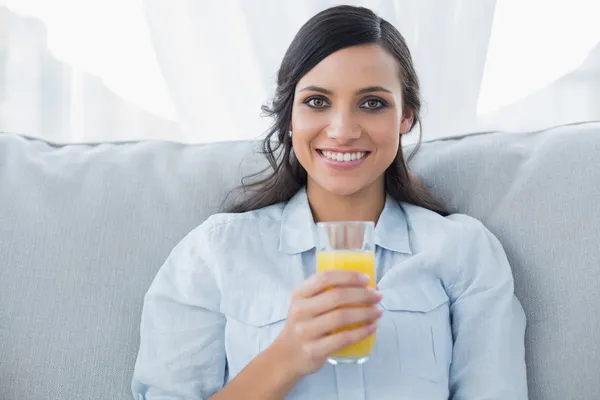 Morena alegre tendo suco de laranja — Fotografia de Stock