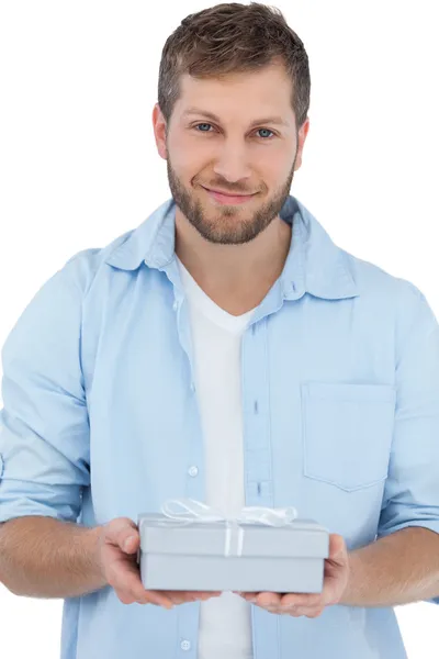Handsome man holding a present looking at camera — Stock Photo, Image