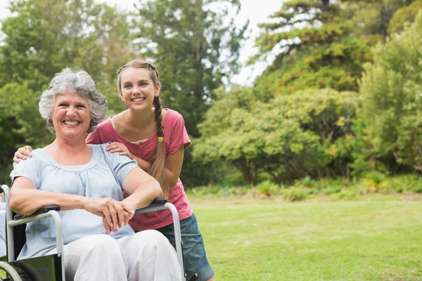 Abuela en silla de ruedas y nieta sonriendo en la leva — Foto de Stock