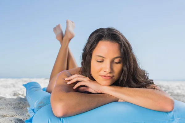 Pensive attractive brunette relaxing on her lilo — Stock Photo, Image