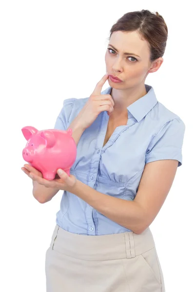 Thoughtful businesswoman with piggy bank — Stock Photo, Image