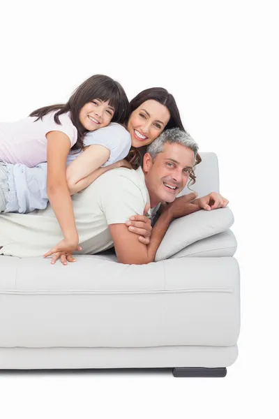 Little girl lying on her parents on sofa — Stock Photo, Image