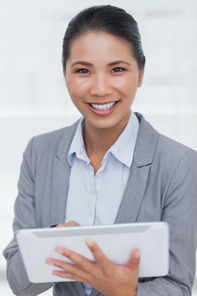 Sorrindo empresária posando rolagem em seu tablet pc — Fotografia de Stock