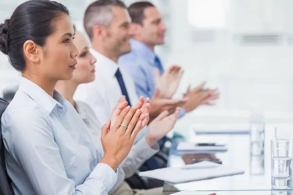 Ernsthafte Mitarbeiter applaudieren für eine Präsentation — Stockfoto