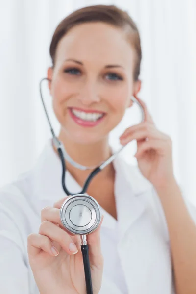 Smiling pretty nurse posing holding her stethoscope — Stock Photo, Image