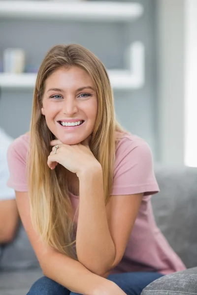 Mulher feliz sentada no sofá — Fotografia de Stock