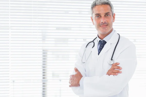 Médico sorridente cruzando os braços — Fotografia de Stock