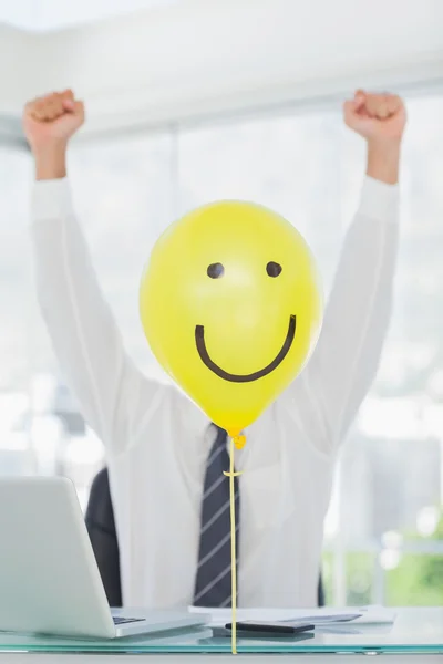 Κίτρινο μπαλόνι με χαρούμενο πρόσωπο κρύβεται businessmans χαρούμενο πρόσωπο — Φωτογραφία Αρχείου