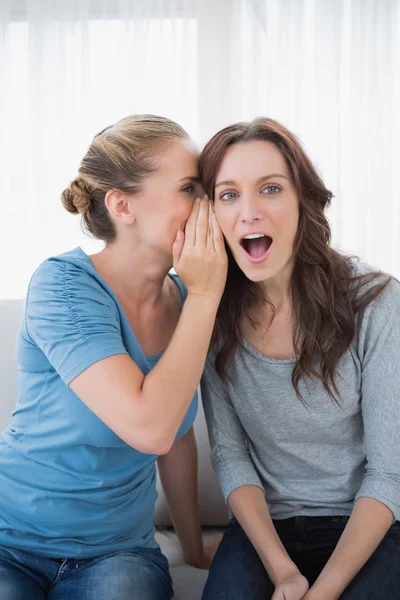 Mujer asombrada siendo contada un secreto por su amiga —  Fotos de Stock
