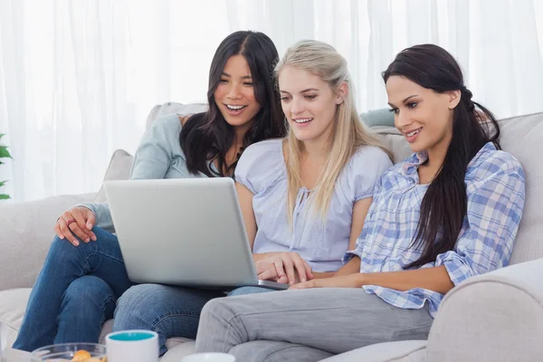 Lachende vrienden kijken laptop samen — Stockfoto