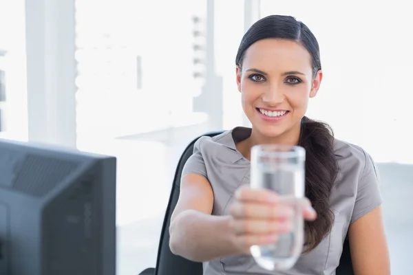 Smiling gorgeous secretary offering water — Stock Photo, Image