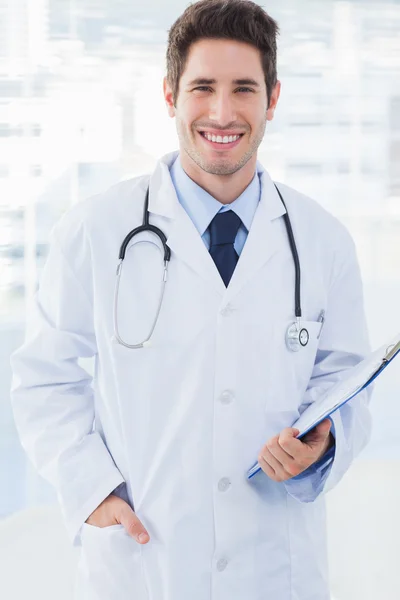 Médico segurando arquivos e sorrindo para a câmera — Fotografia de Stock