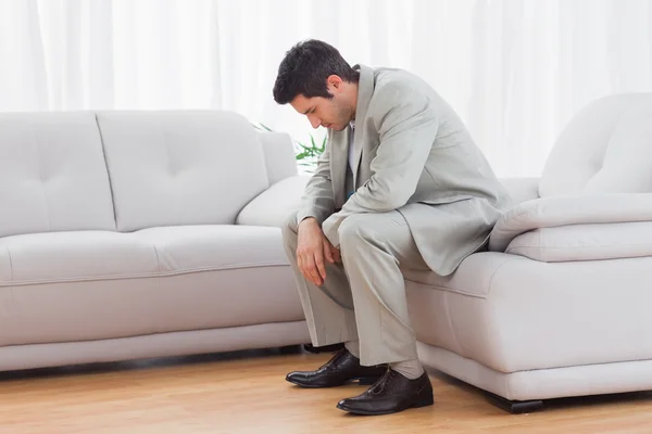 Infeliz buitre sentado en el sofá bajando la cabeza — Foto de Stock