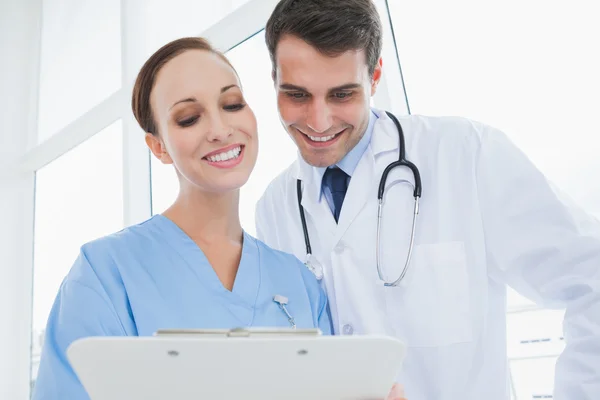 Cheerful doctor and surgeon viewing documents together Stock Photo