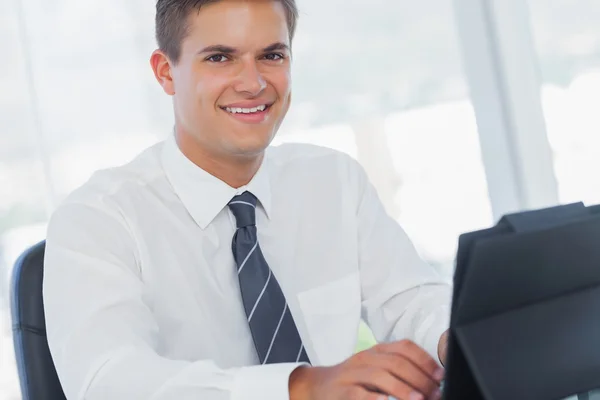 Sonriente joven empresario que trabaja en su PC tableta Fotos de stock