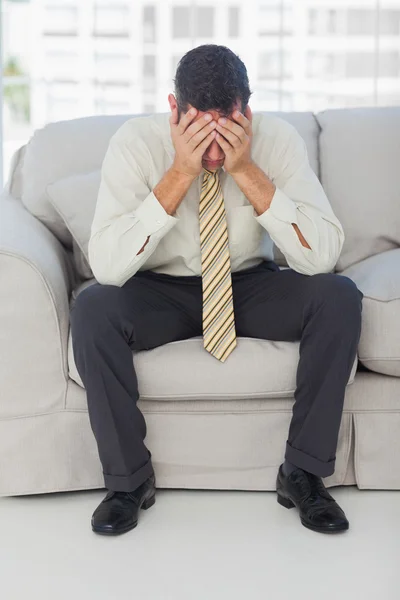 Hombre de negocios problemático sentado en el sofá — Foto de Stock