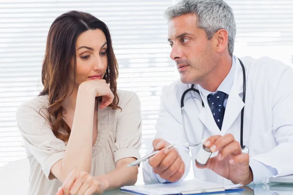 Serious doctor listening to his patient Stock Image
