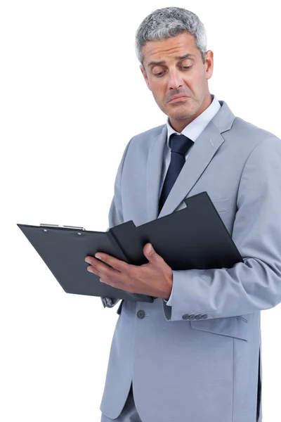 Disappointed businessman holding clipboard Stock Photo