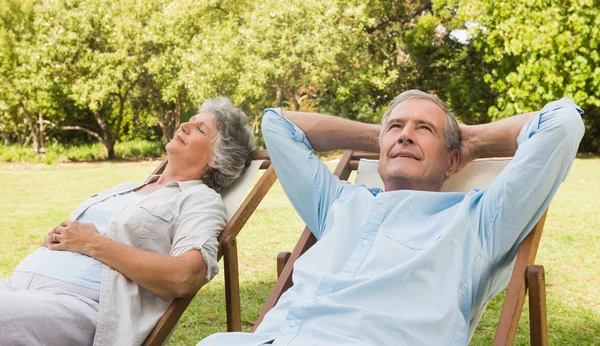 Entspannendes reifes Paar sitzt auf Sonnenliegen — Stockfoto