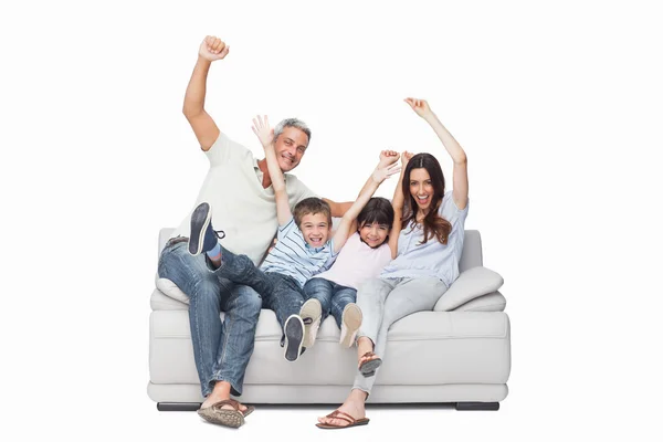 Familie zittend op de bank verhogen van hun wapens — Stockfoto