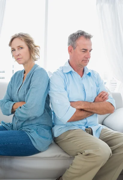 Paar mittleren Alters sitzt auf dem Sofa und spricht nach einem Schwindel nicht mehr — Stockfoto