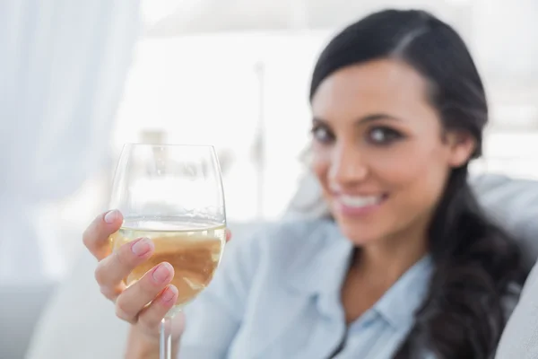 Morena atraente oferecendo vinho branco para câmera — Fotografia de Stock