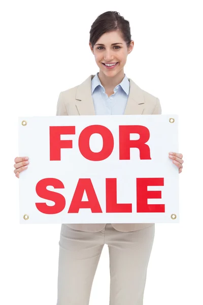 Smiling businesswoman with for sale sign — Stock Photo, Image