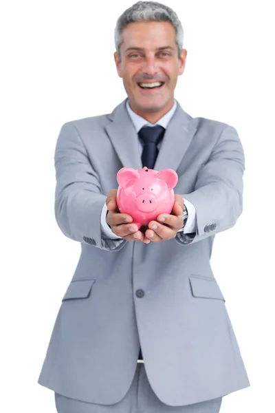 Wide smiling businessman holding piggy bank — Stock Photo, Image
