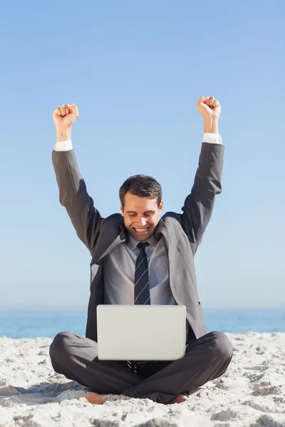 Overwinnaar jonge zakenman kijken naar zijn laptop — Stockfoto