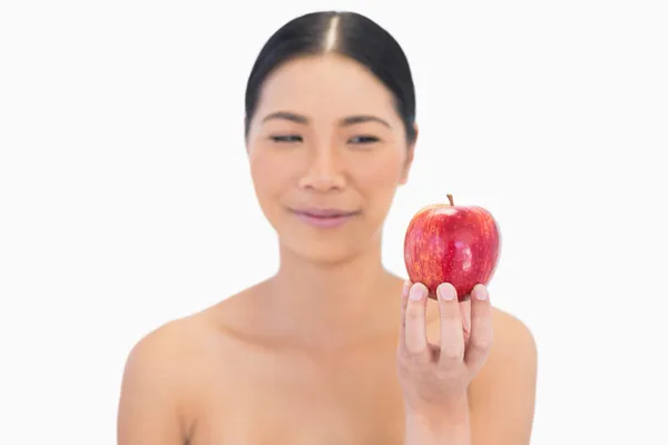 Avslappnad naturlig brunett håller rött äpple — Stockfoto