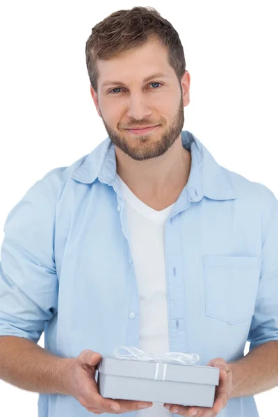 Hombre guapo sosteniendo un regalo mirando a la cámara — Foto de Stock