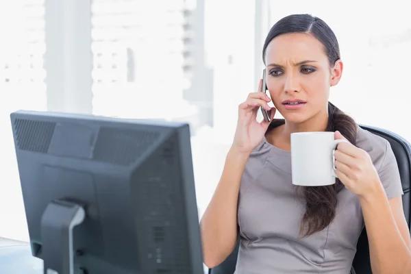 Stirnrunzeln Geschäftsfrau mit Kaffee und Anrufbeantworter — Stockfoto