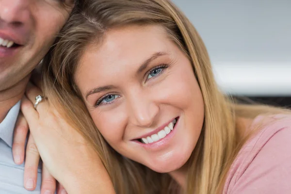 Feliz casal sentado no sofá sorrindo para câmera foco no wom — Fotografia de Stock