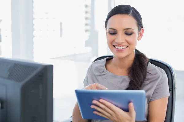 Alegre secretaria atractiva desplazándose en la tableta pc — Foto de Stock