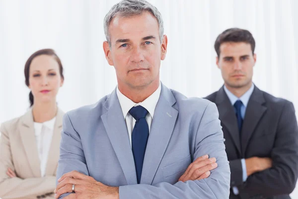 Homem de negócios sério posando com sua equipe de trabalho — Fotografia de Stock