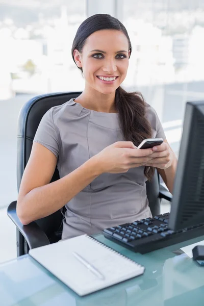 Glada vacker affärskvinna textning på sin smartphone — Stockfoto
