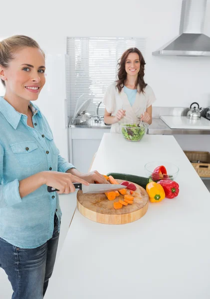 Mulheres sorrindo cozinhar juntos e olhando para a câmera — Fotografia de Stock