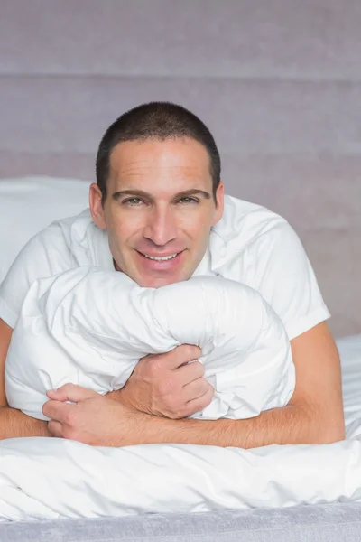 Hombre alegre abrazando su almohada — Foto de Stock