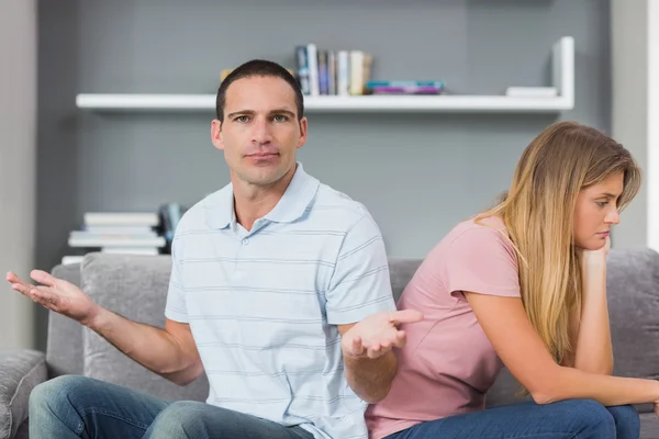 Couple sitting back to back after a fight on the couch with man — Stock Photo, Image