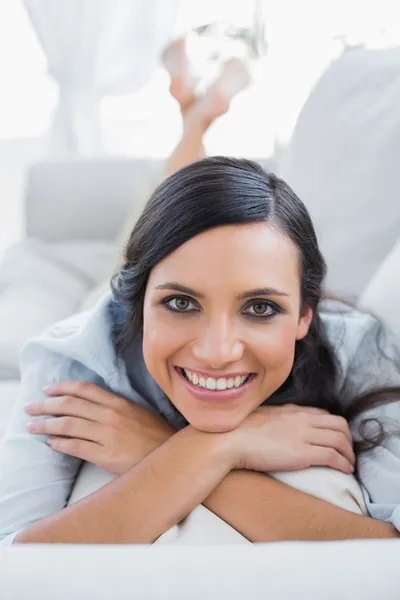 Mulher de cabelo escuro alegre deitada no sofá — Fotografia de Stock