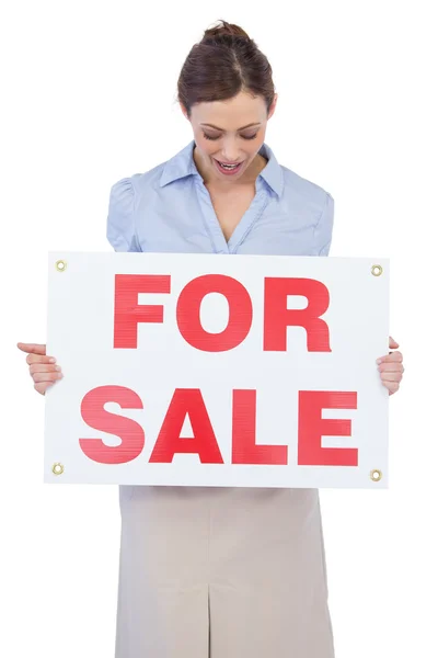 Happy estate agent posing with for sale sign — Stock Photo, Image