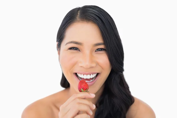 Hermosa modelo de pelo castaño comiendo fresa — Foto de Stock