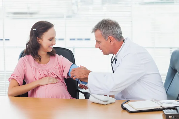 Médico tomando pressão arterial de paciente grávida — Fotografia de Stock