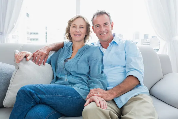 Paar mittleren Alters entspannt sich auf der Couch — Stockfoto