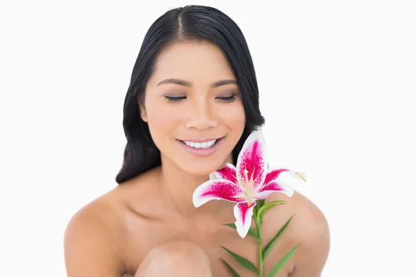 Cheerful natural black haired model posing with lily — Stock Photo, Image