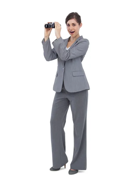 Mujer de negocios asombrada posando con prismáticos — Foto de Stock