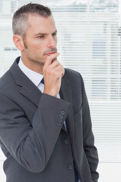 Pensiero uomo d'affari posa con il dito sul mento — Foto Stock