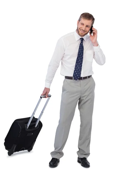 Красивый бизнесмен с чемоданом и телефоном — стоковое фото