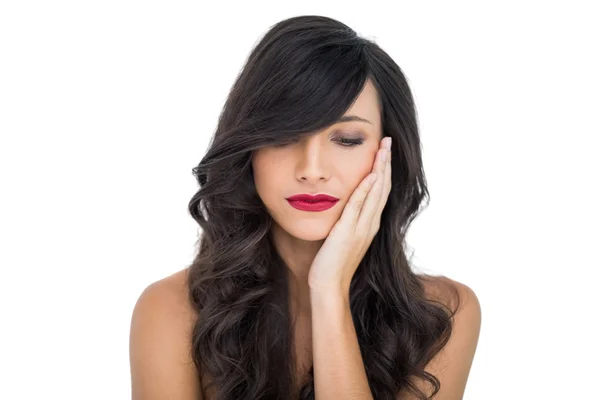 Thoughtful sexy brunette with red lips touching her cheek — Stock Photo, Image