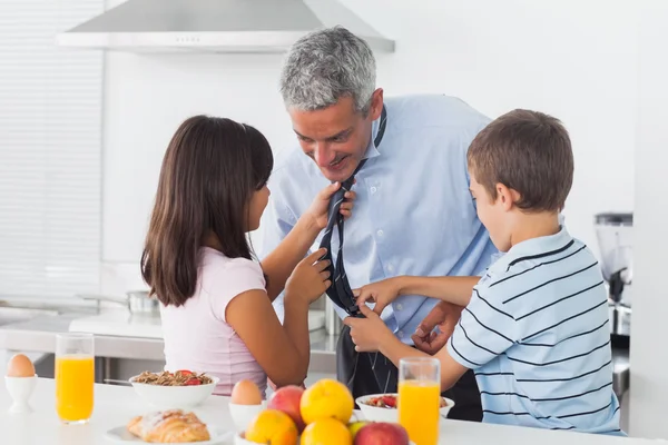 Los niños arreglando a sus padres atan en la cocina —  Fotos de Stock